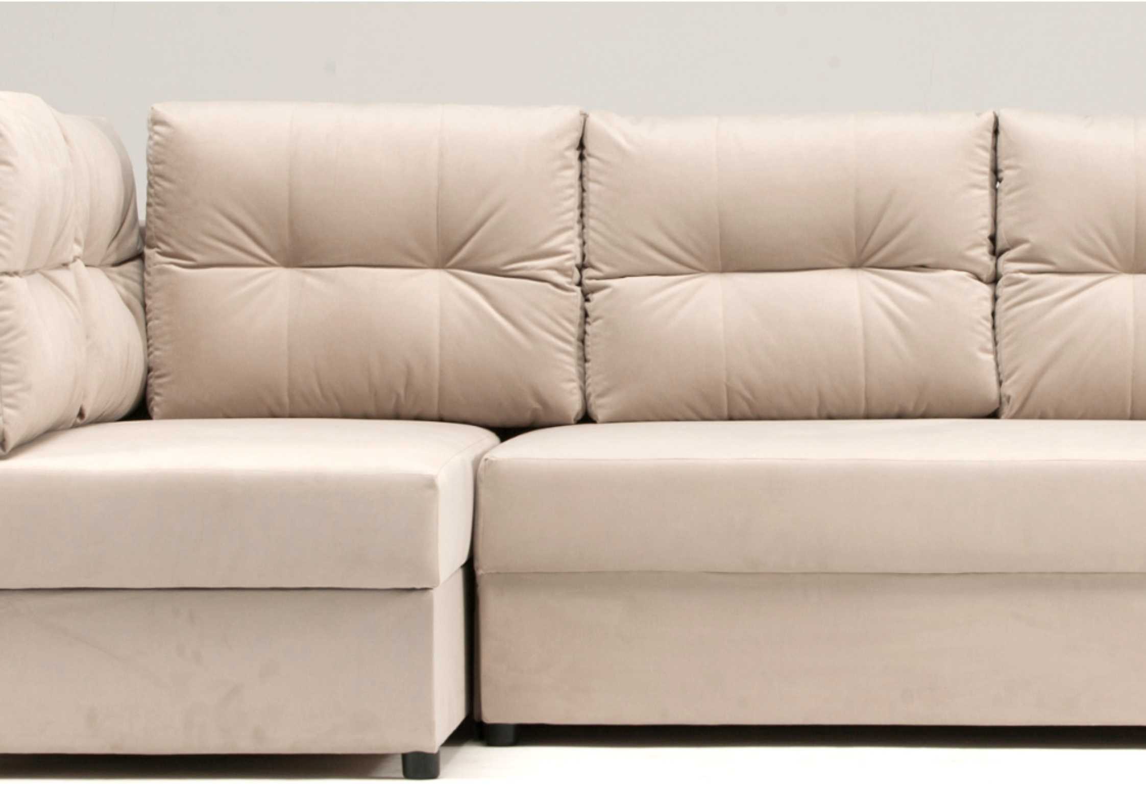 Mały beżowy narożnik z pikowanymi poduszkami